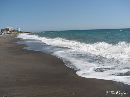 Strand mit Leuchtturm im Hintergrund
